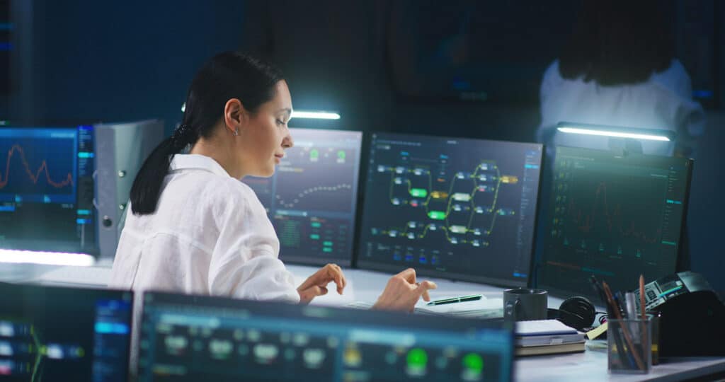 Female IT technical specialist works on computer with data